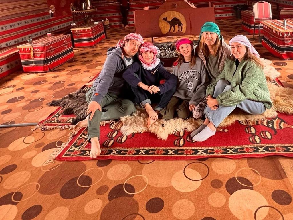 a group of people sitting on a rug on the floor at Wadi Rum Meteorite camp in Wadi Rum