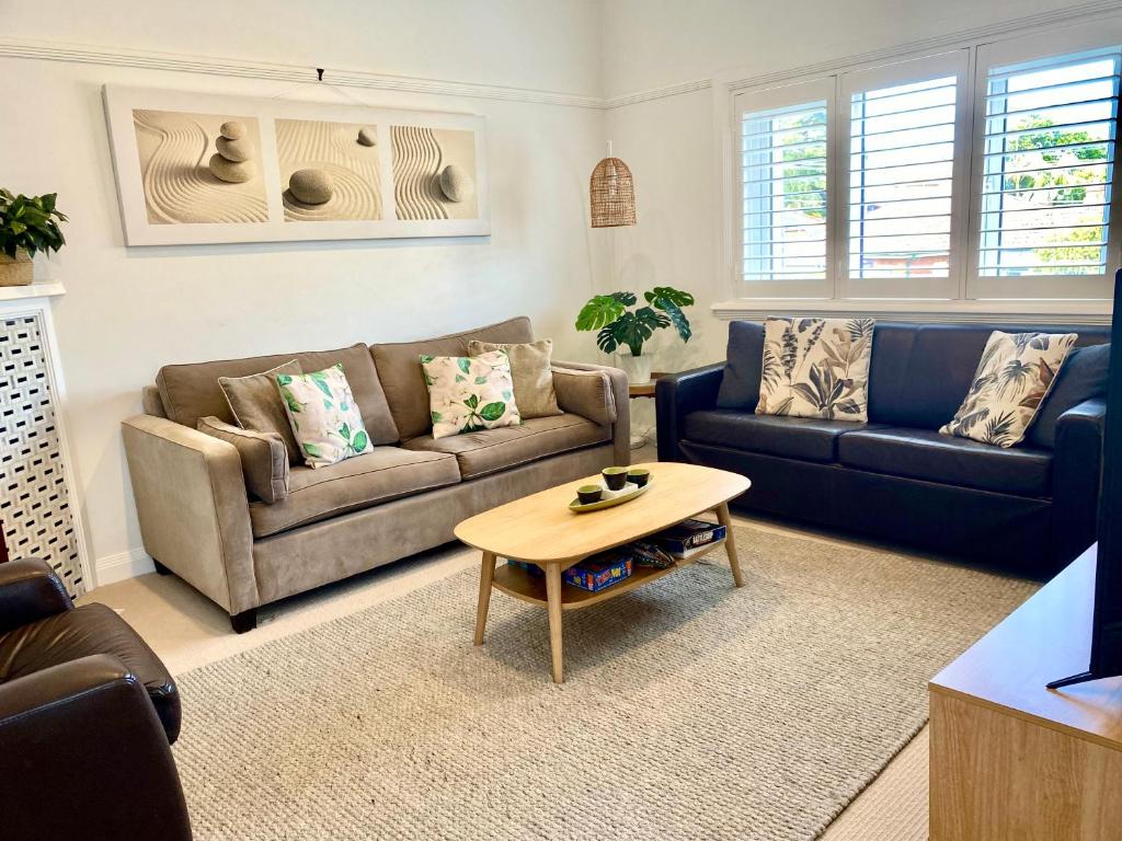 uma sala de estar com dois sofás e uma mesa de centro em Family Getaway to Manly Beach plus free onsite parking, stroll to beach, cafes em Sydney