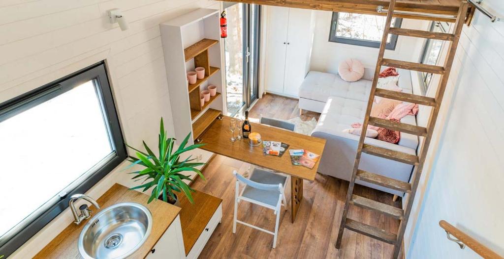 a tiny house with a ladder and a living room at Tiny House w Camp Gorący Potok in Szaflary