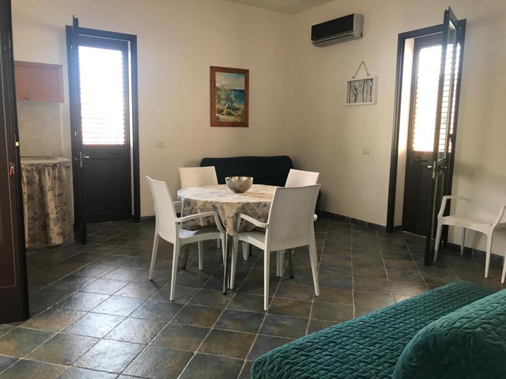 Appartamenti L'Approdo del Gabbiano في لامبيدوسا: غرفة طعام مع طاولة وكراسي