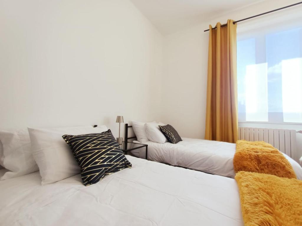 1 dormitorio con 2 camas y ventana en ArtGallery Apartment - Villa immersa nel verde - Deluxe, en Viterbo