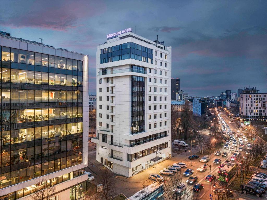 a tall white building in a city with traffic at Mercure Bucharest Unirii in Bucharest