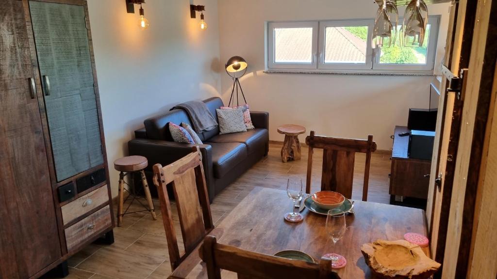uma sala de estar com uma mesa e um sofá em Villa Bonita del Kaiserstuhl FeWo1 em Sasbach am Kaiserstuhl