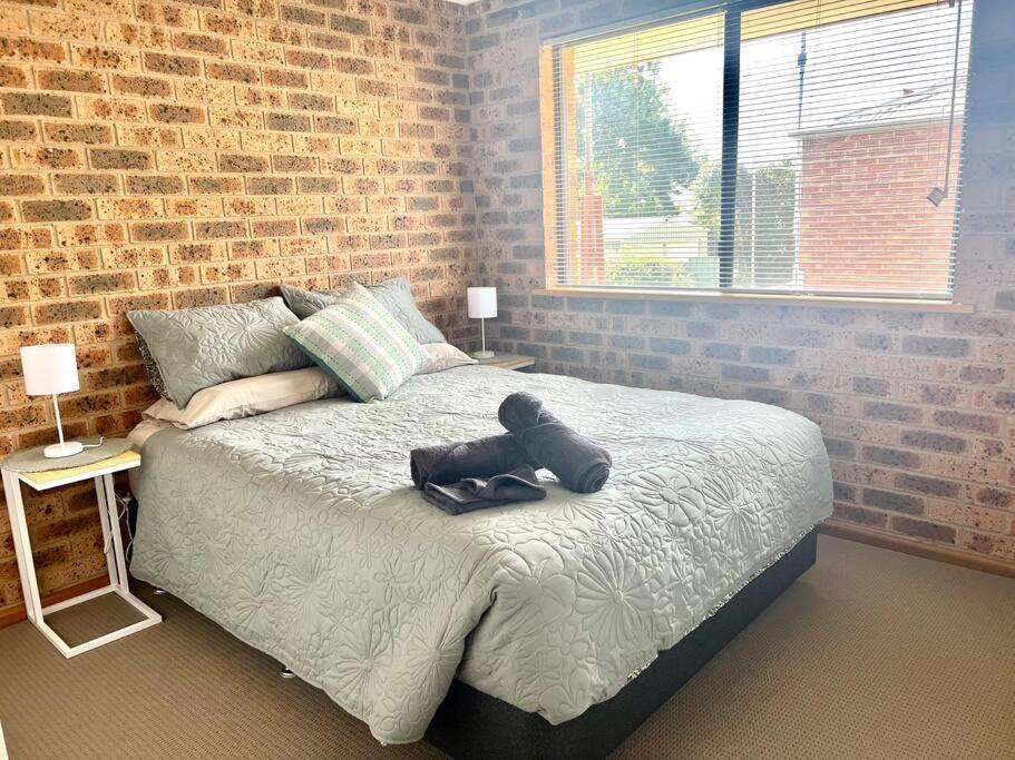 a teddy bear sitting on a bed in a bedroom at Stay on Lachlan in Cowra
