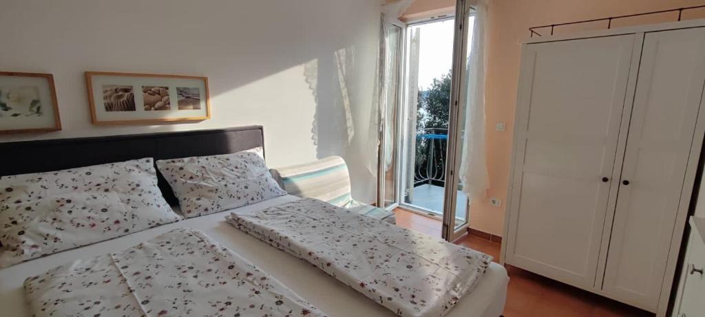 茨里克韋尼察的住宿－Ivana apartman 3，卧室配有带枕头的床铺和窗户。