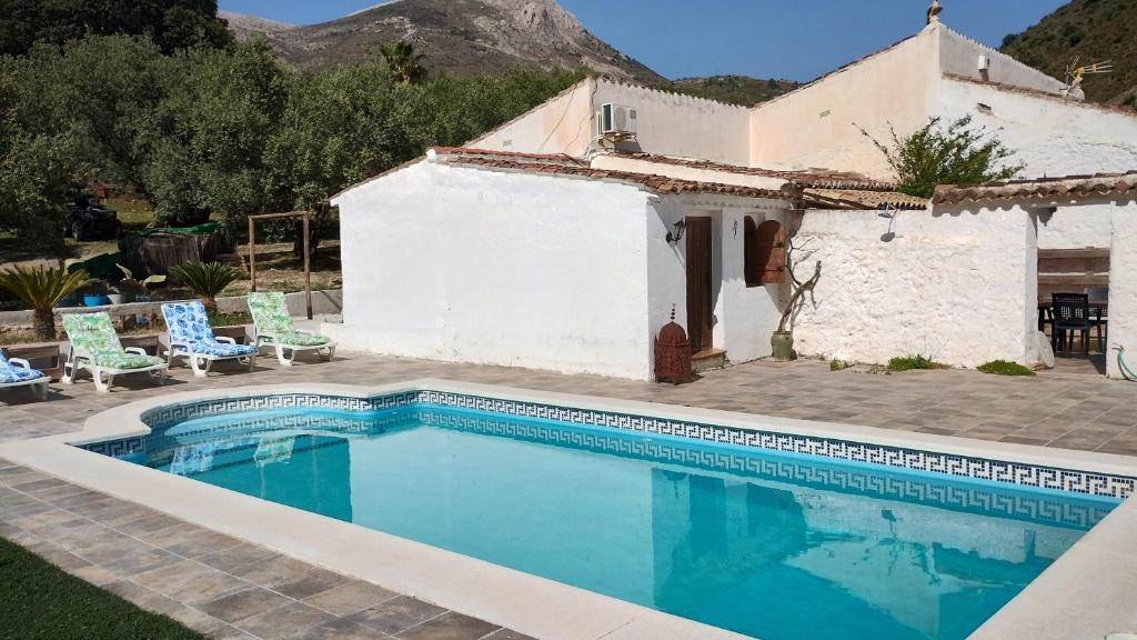 Villa con piscina frente a una casa en El Ventorrillo la alegría en Málaga