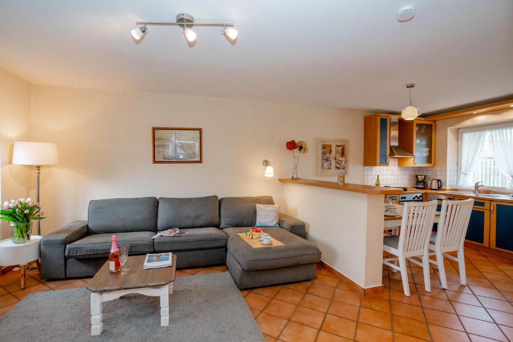 a living room with a couch and a kitchen at Godewind ebenerdig in Westerland