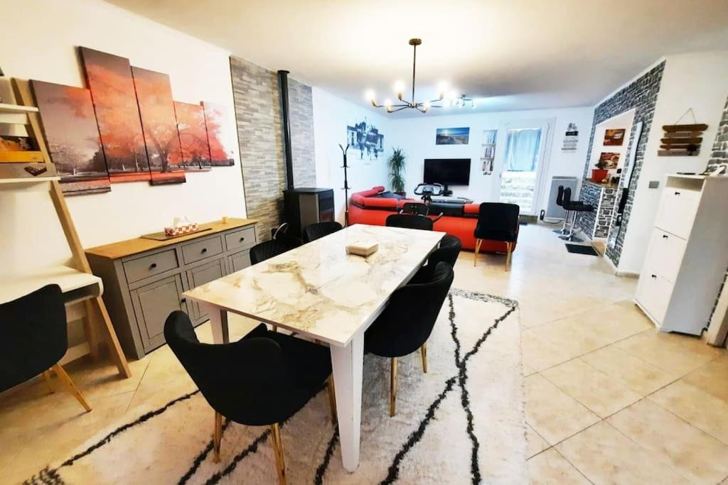a kitchen and living room with a table and chairs at Villa confortable avec Jacuzzi à Chevannes in Chevannes