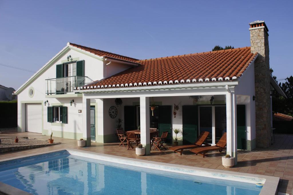 a house with a swimming pool in front of a house at Casa Delbon Guest House in Aljezur