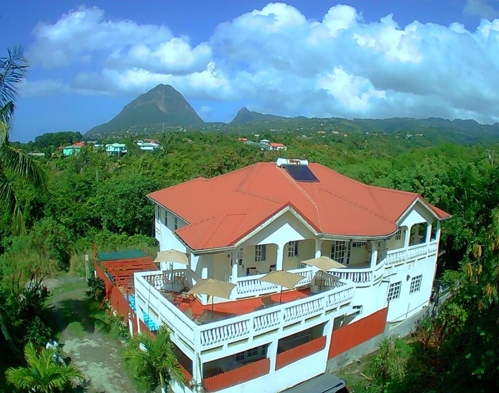 a house with a red roof with mountains in the background at Comfort Suites - Special in Choiseul