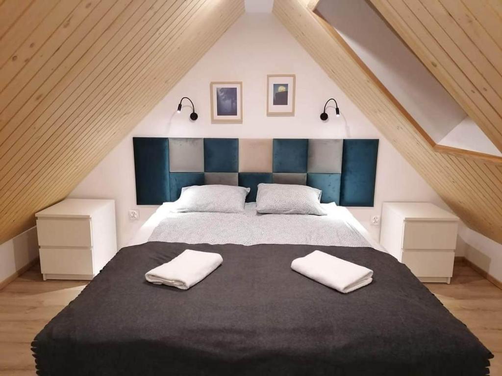 杜什尼基茲德魯伊的住宿－Stara Kuźnia，一间卧室配有一张大床和两条毛巾