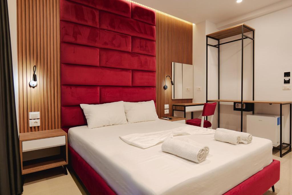 a bedroom with a large bed with a red wall at Vila Shpetimi in Ksamil