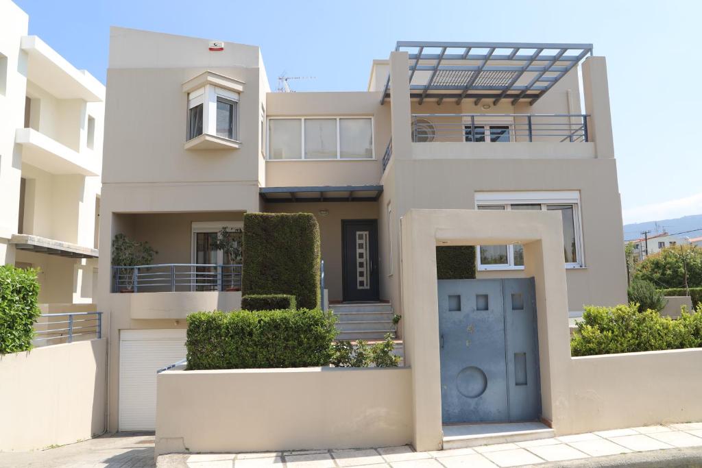 a large white house with a blue door at Evimerou Villa in Kos