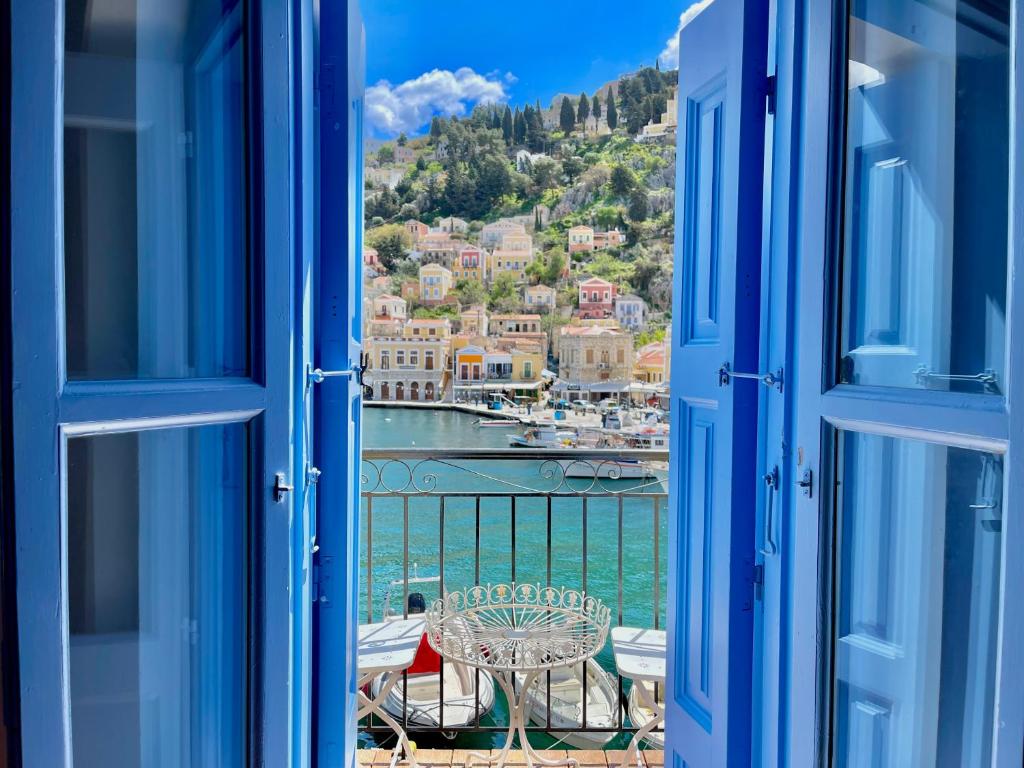 an open window with a view of a harbor at Nikolakis, Seafront - Harbor view in Symi
