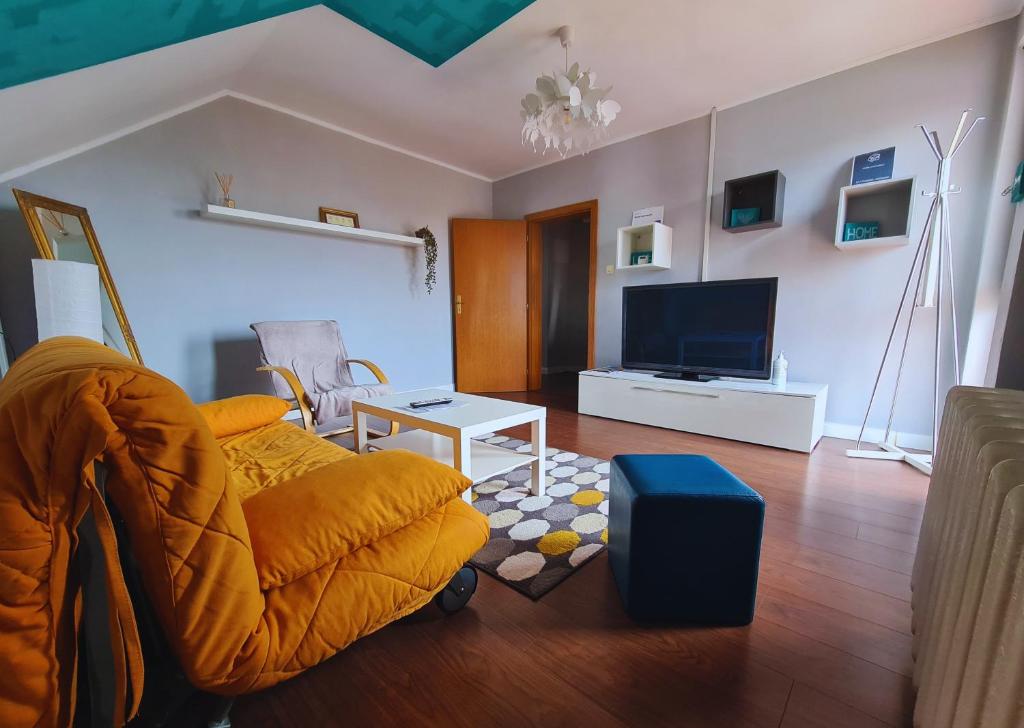 een woonkamer met een bank en een televisie bij Nosen Apartment in Bistriţa