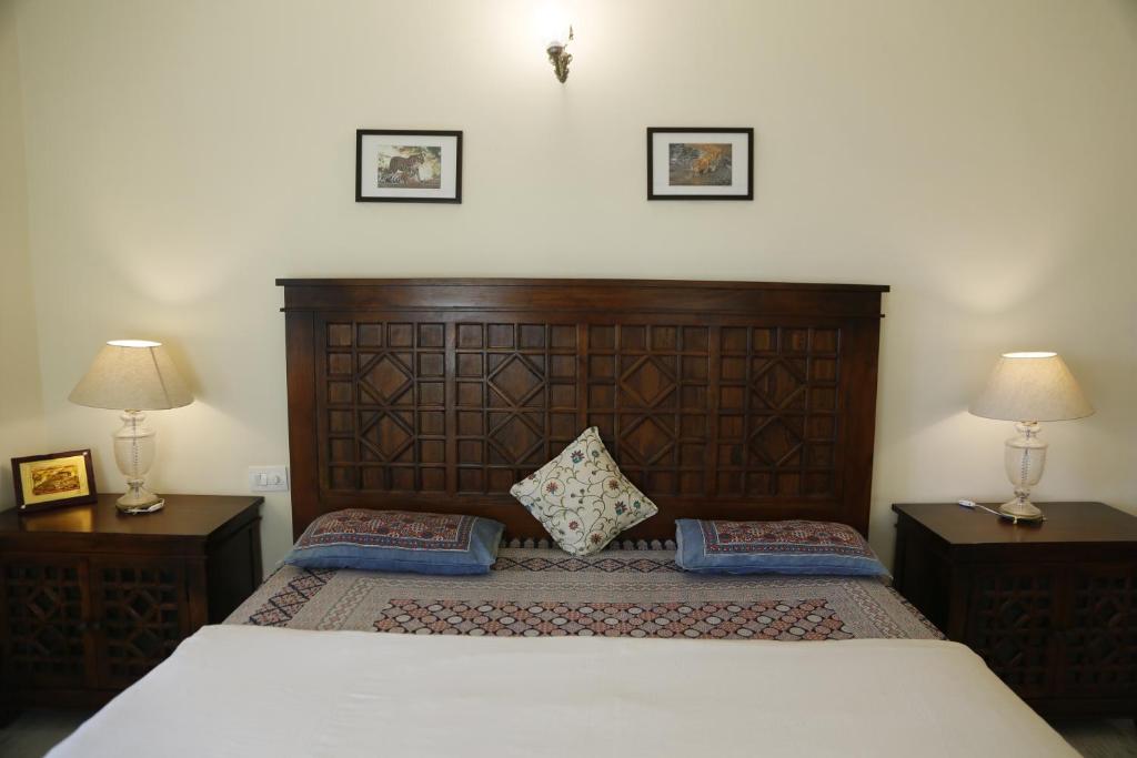 a bedroom with a large wooden bed with two lamps at Jai Villa Homestay in Udaipur