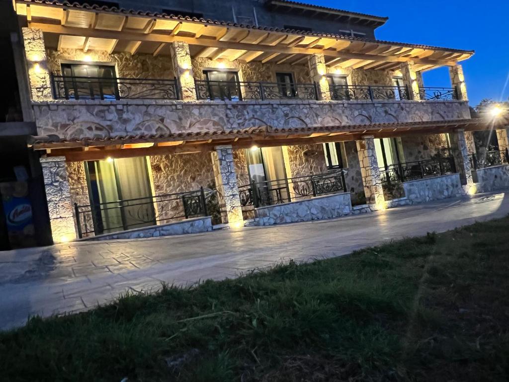 a large stone building with a balcony at night at Stonevilla Buta in Himare