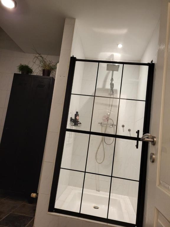 a glass door with a shower in a room at Bij Sarah in Leopoldsburg