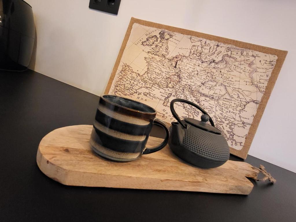 a cup and a phone sitting on a wooden cutting board at Bij Sarah in Leopoldsburg