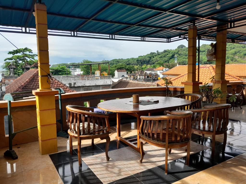 a table and chairs on a balcony with a view at Harmony Guest House in Padangbai