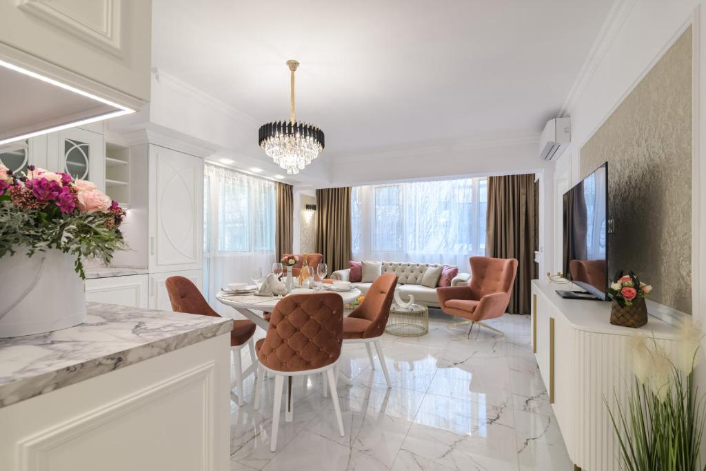 a dining room and living room with a table and chairs at ЛУКС НА МОРЕ Luxury apartment in downtown with garage in Varna City