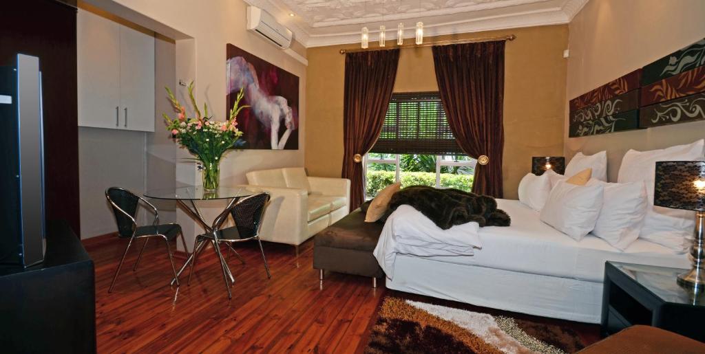 a living room filled with furniture and a large window at Saffron Guest House in Johannesburg