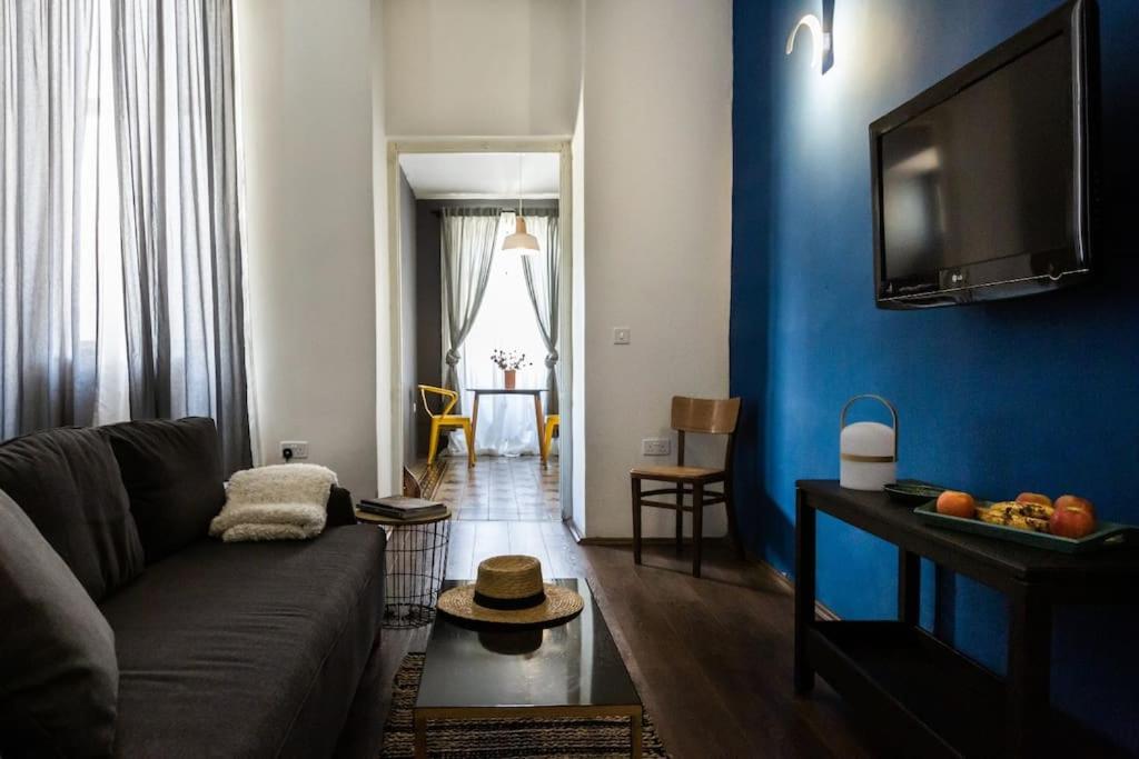 a living room with a couch and a blue wall at Townhouse with dreamy terrace in Valletta