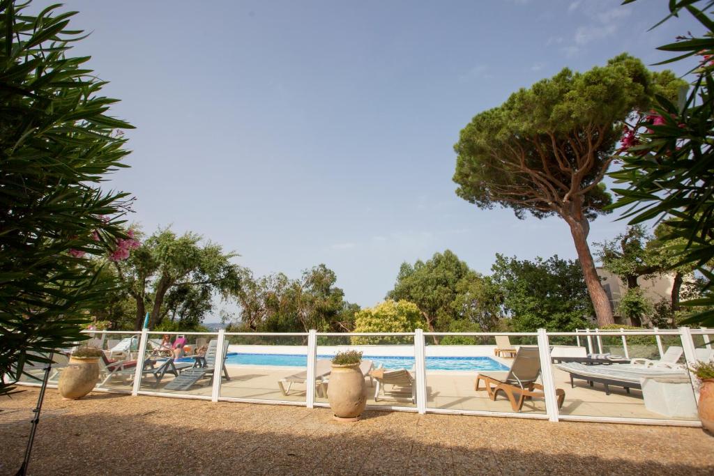 una piscina con una valla blanca junto a un complejo en BE COOL, golfe de saint tropez - Piscine, en Saint-Tropez