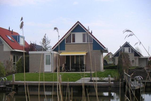 a house on a dock next to a body of water at Ark in Terherne