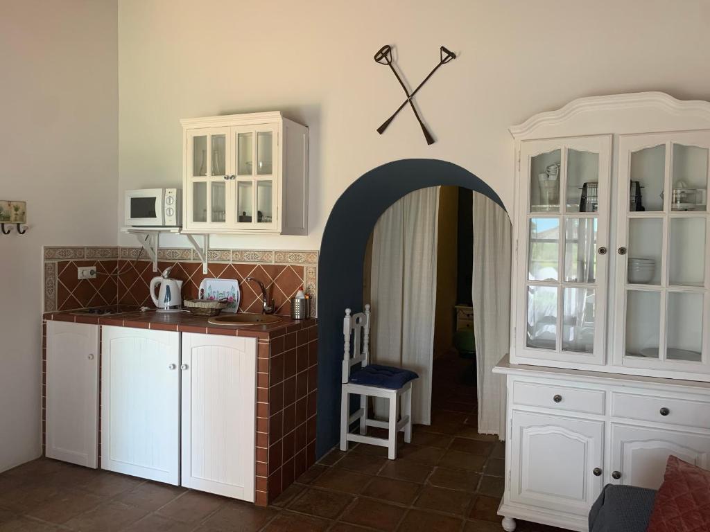 a kitchen with white cabinets and an archway at Molino El Mastral in Tarifa