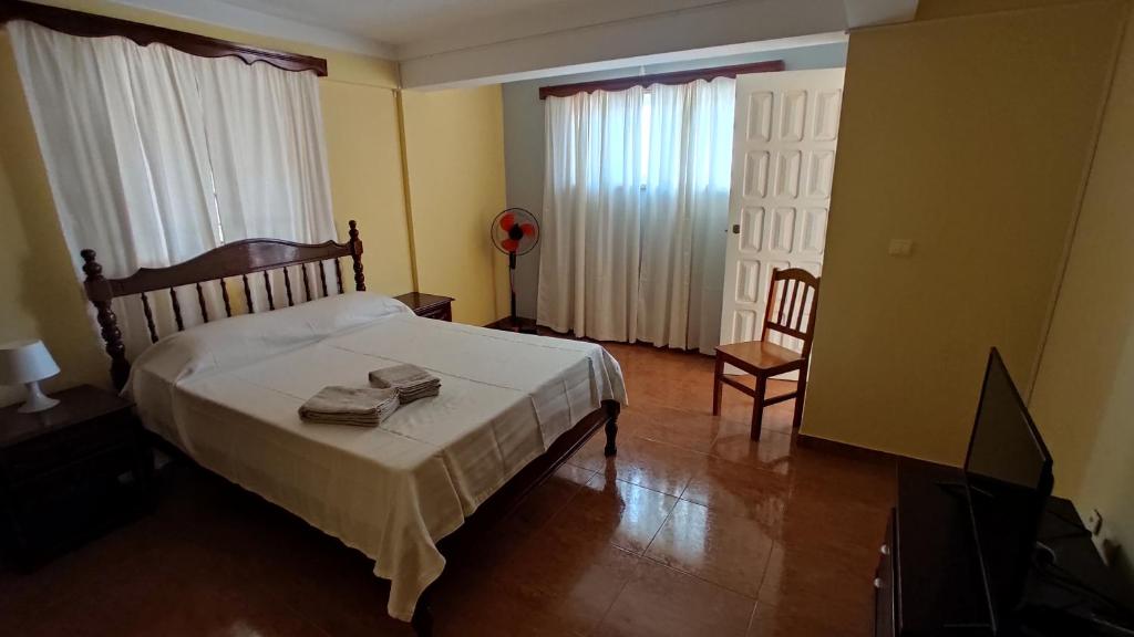 a bedroom with a bed and a chair at Apartamento acolhedor com vista para o Monte Cara in Mindelo