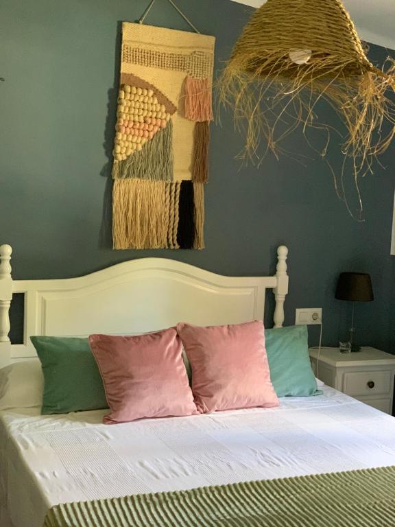 a bedroom with a white bed with pillows at Molino El Mastral in Tarifa