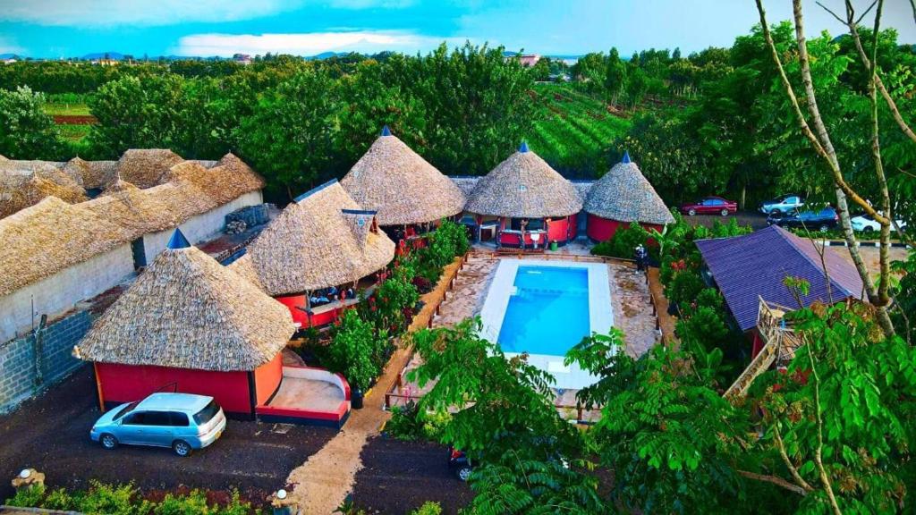 an aerial view of a group of huts with a pool at Jambo Afrika Resort in Emali
