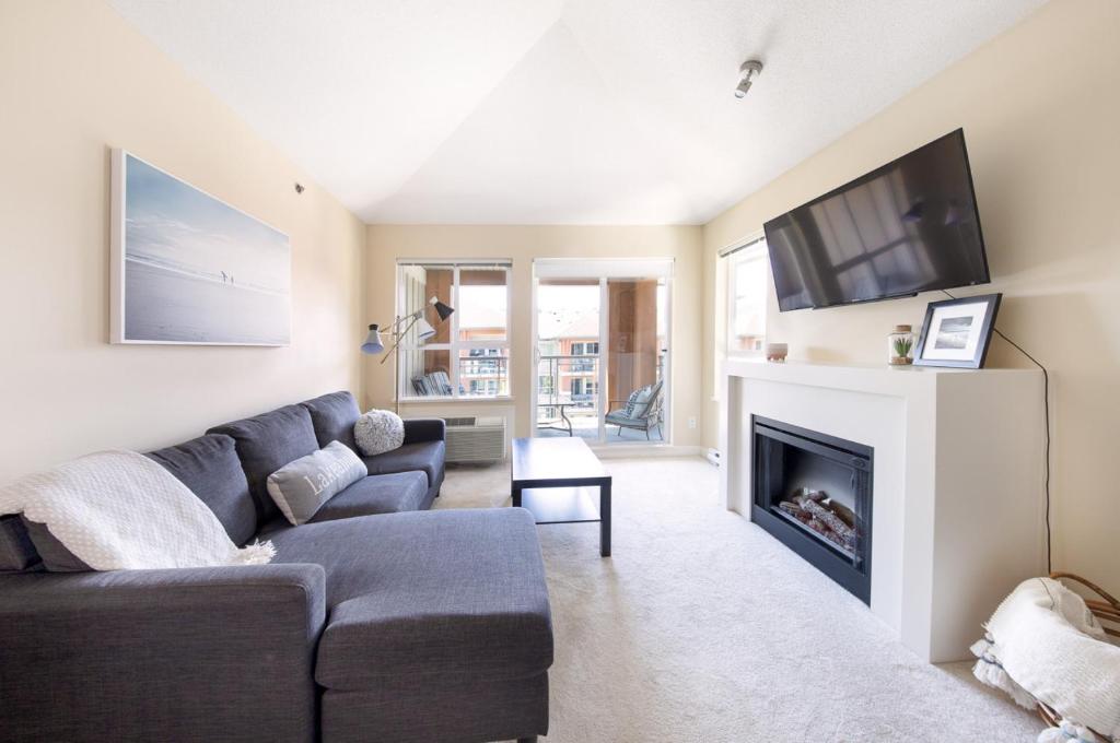 a living room with a couch and a fireplace at Downtown Osprey Condo at Waterscapes in Kelowna