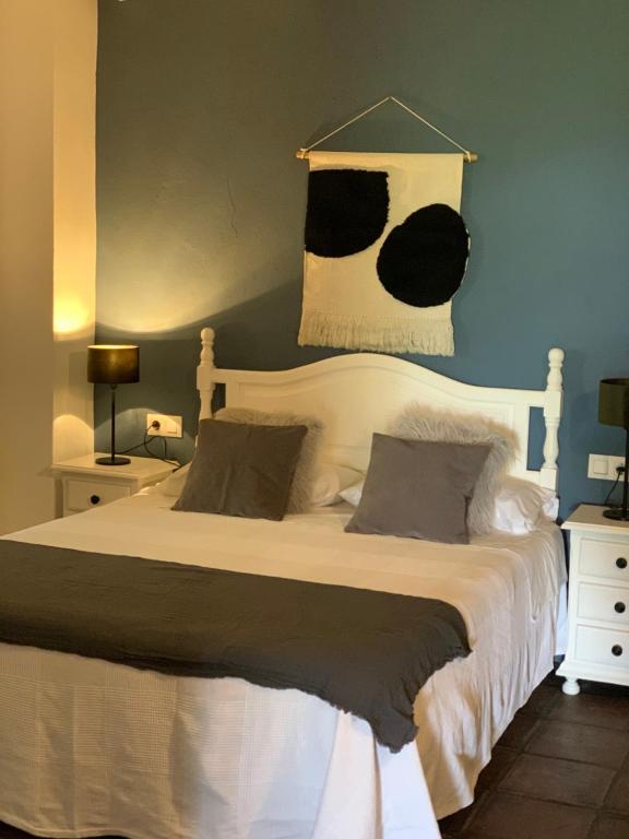 a bedroom with a large bed with black and white sheets at Molino El Mastral in Tarifa