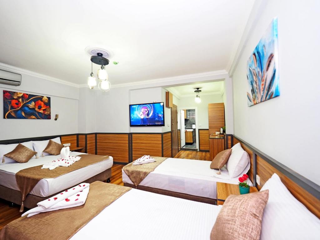 Habitación de hotel con 2 camas y TV de pantalla plana. en Arges old city hotel, en Estambul
