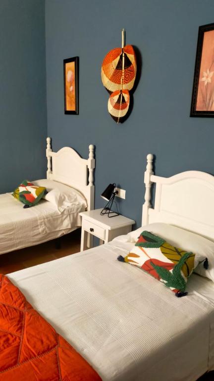 two beds in a room with blue walls at Molino El Mastral in Tarifa