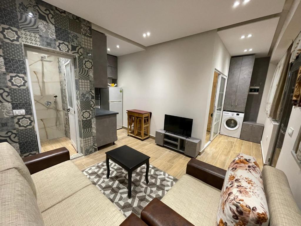 Una sala de estar con un sofá y un televisor. en Modern 1 Bedroom City Apartment, en Tirana