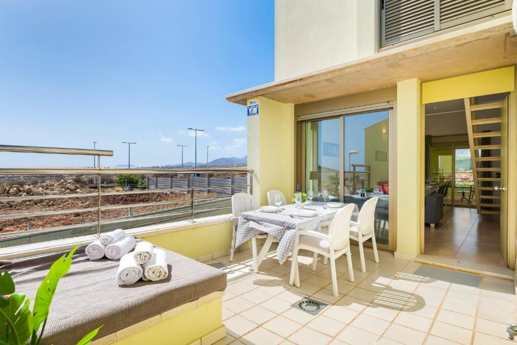 a patio with a table and chairs on a balcony at MEDANO4YOU Los Patios Family and Sports Home in El Médano