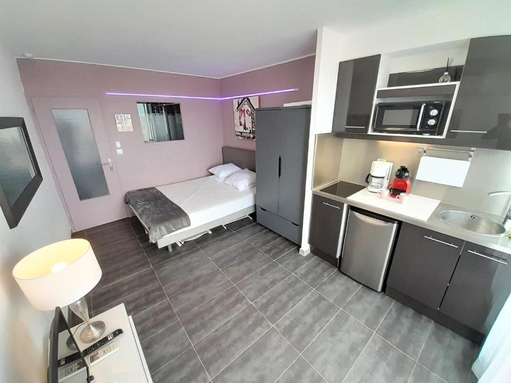 Cette petite chambre comprend un lit et une cuisine. dans l'établissement Studio Village Naturiste Baby Doll, au Cap d'Agde