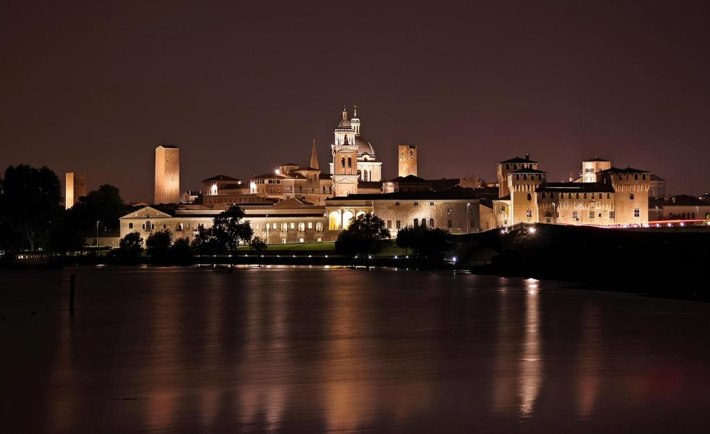 a large castle at night with a large body of water at Suite Mazzini 23 in Mantova