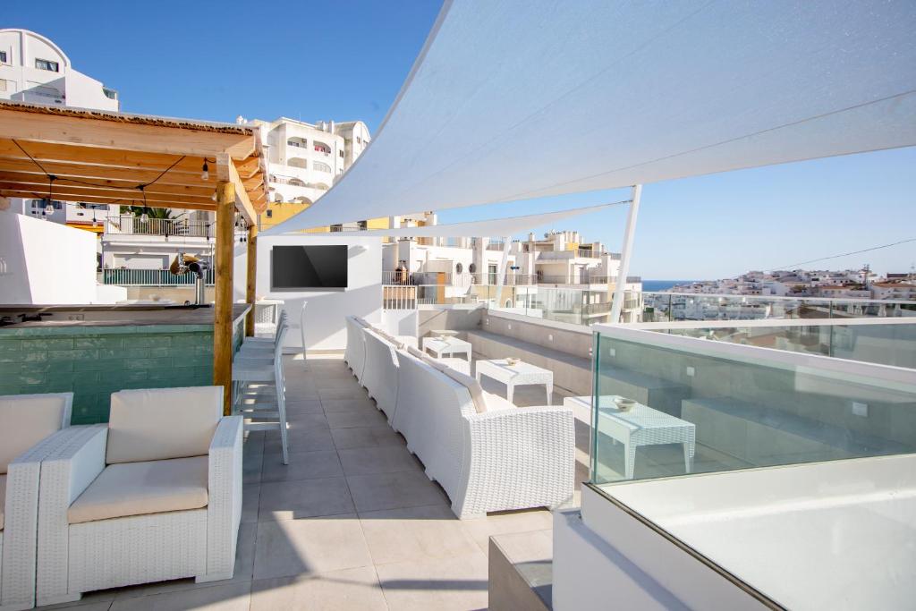 balcón con sillas blancas y vistas a la ciudad en Sun Lovers Hostel, en Albufeira
