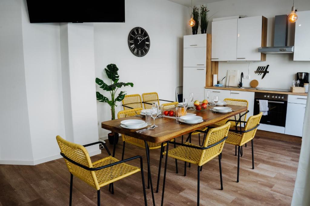 a kitchen and dining room with a wooden table and chairs at Jenapartments Design Loft, Damenviertel im Stadtzentrum in Jena