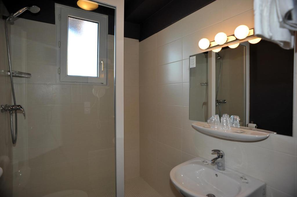 y baño con ducha, lavabo y espejo. en Hôtel Chez Pierre d'Agos, en Agos-Vidalos