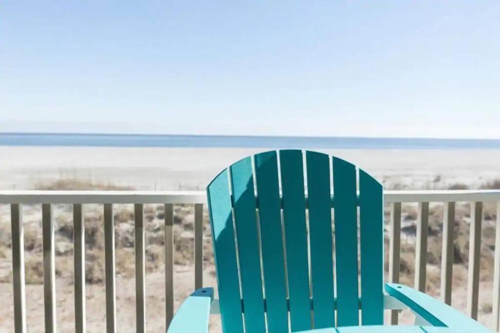une chaise bleue assise sur un balcon donnant sur la plage dans l'établissement Port O' Call B201 - Direct Oceanfront Views, à Isle of Palms