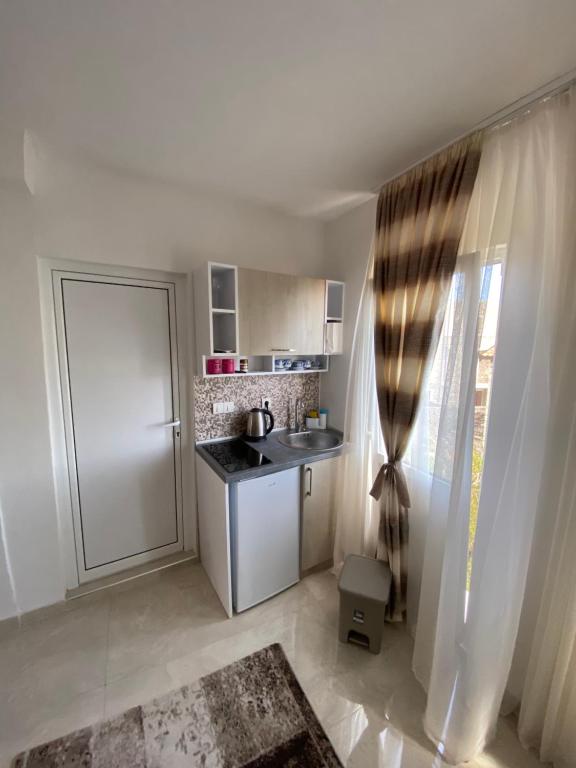 a small kitchen with a sink and a refrigerator at Apartments Gusar in Ulcinj