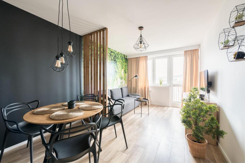 uma sala de jantar com uma mesa e cadeiras num quarto em Prime Apartments - Oliva View em Gdansk