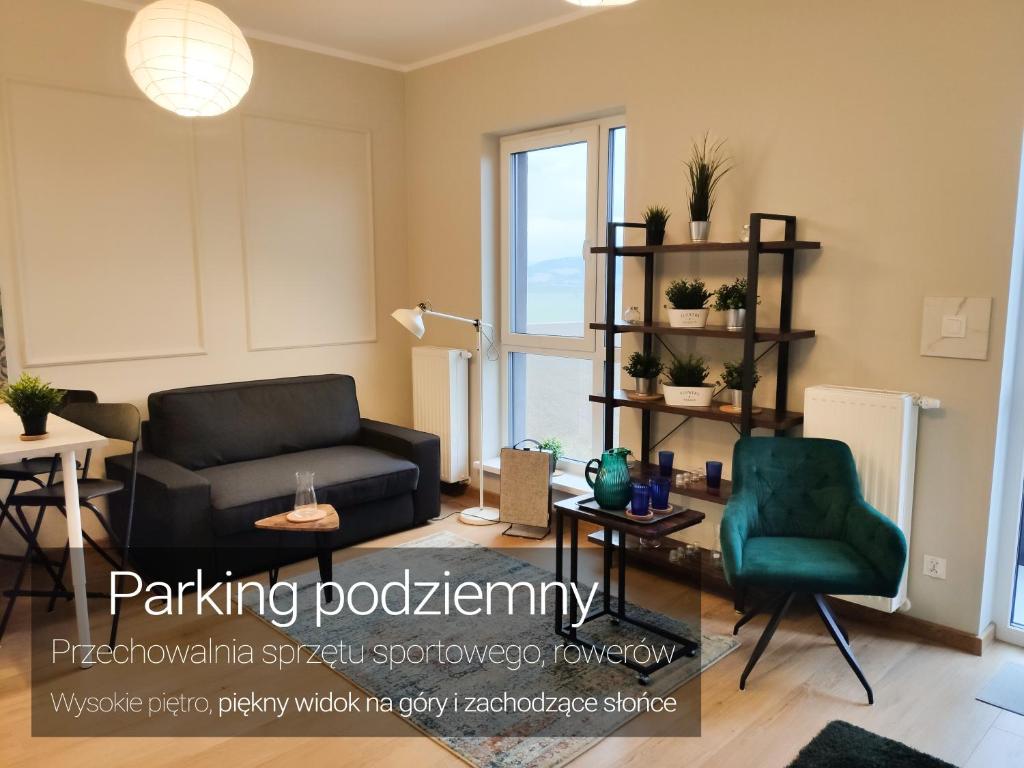 a living room with a couch and a chair at Apartament na Letniej 53m2 z Widokiem na Góry Kłodzko - Przyjaciół Ziemi Kłodzkiej in Kłodzko