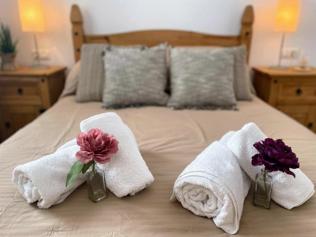 - un lit avec des serviettes et des fleurs dans des vases dans l'établissement La Ciñuelica R14 First Floor Apartment L126, à Orihuela