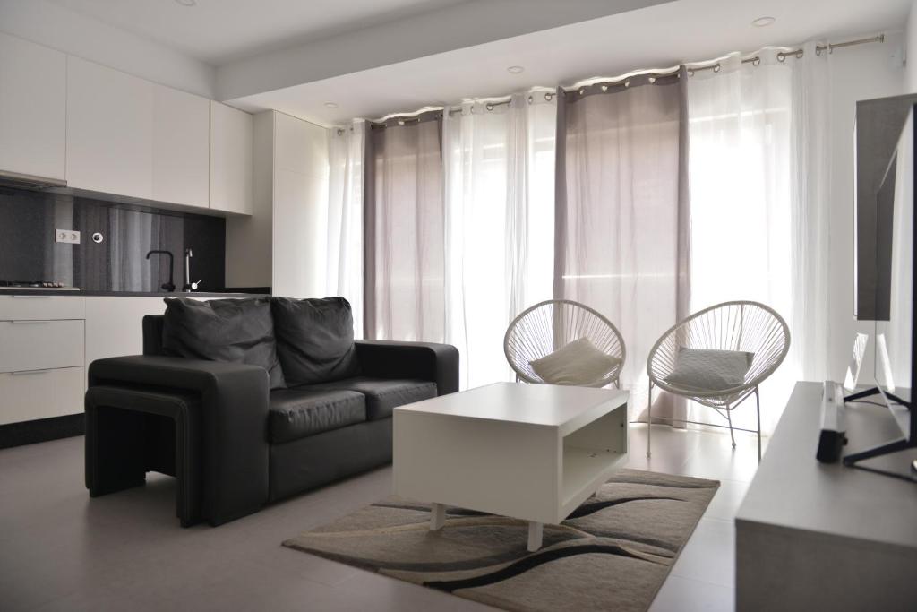 een woonkamer met een bank en een tafel en stoelen bij Duarte Apartments - Lux in Mindelo